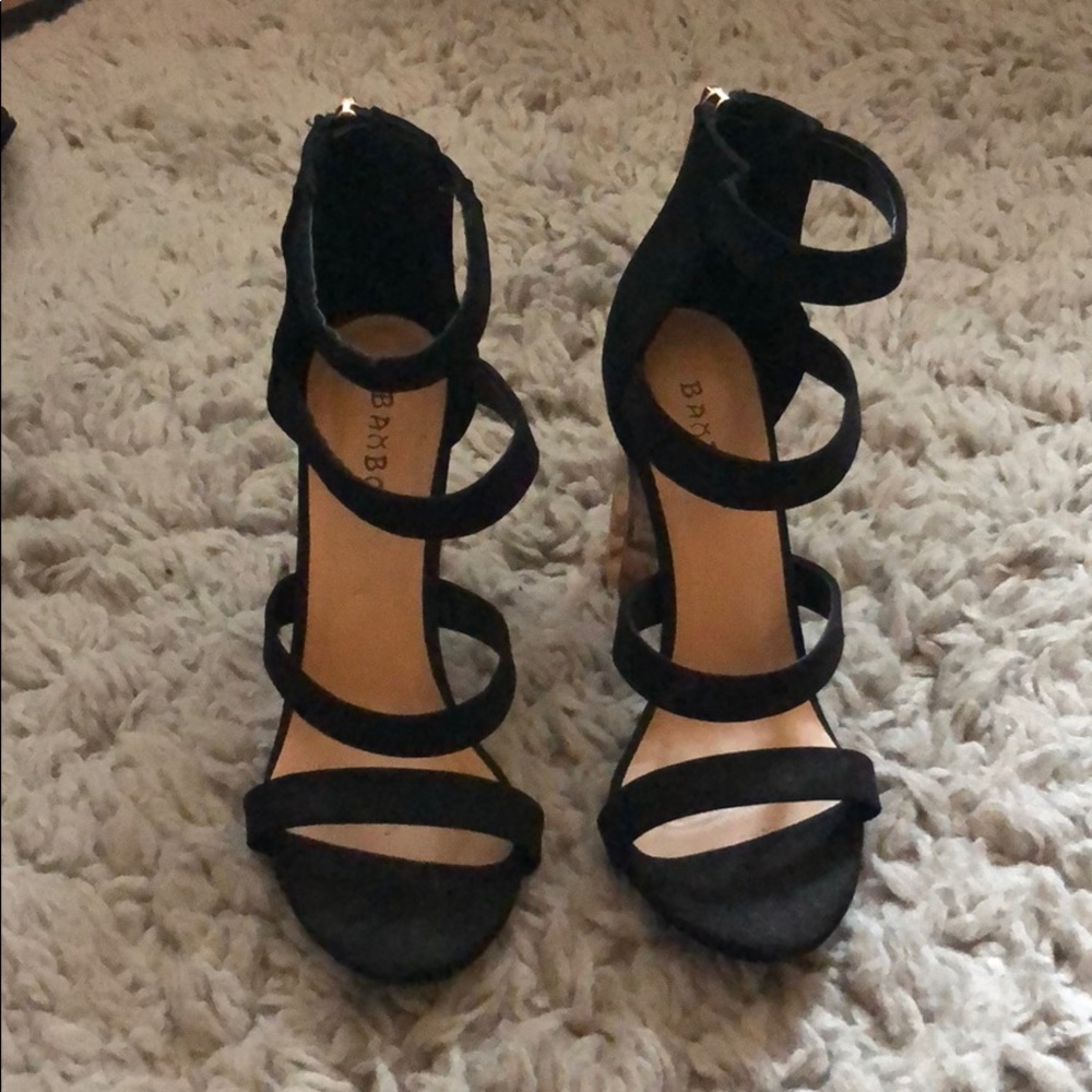 Black strapping heels with a gold heel